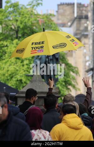 Guide touristique d'Édimbourg lever les mains et un parapluie Publicité Tours gratuits dans une foule de touristes Banque D'Images
