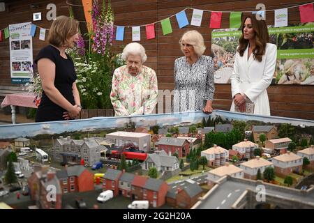 Lindsey Brummitt, directrice du programme à Eden Project, présente un modèle à grande échelle des grands déjeuners qui ont eu lieu au fil des ans à la reine Elizabeth II, La duchesse de Cornouailles et la duchesse de Cambridge lorsqu'ils assistent à un événement au projet Eden pour célébrer l'initiative du Big Lunch, au cours du sommet du G7 à Cornouailles. Date de la photo: Vendredi 11 juin 2021. Banque D'Images