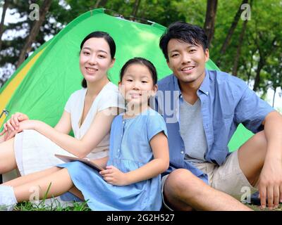 La famille heureuse de trois utilise une tablette informatique en extérieur photo de haute qualité Banque D'Images