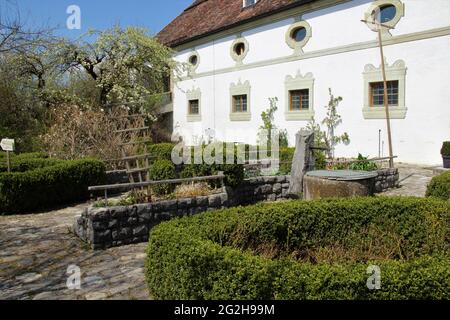 Jardin d'herbes dans le monastère de Benediktbeuern, conçu comme un jardin d'exposition, oasis de calme, centre pour l'environnement et la culture, fleur d'arbre de pomme, maison, boîte, arbre de boîte, chemin, fontaine, pavés Banque D'Images