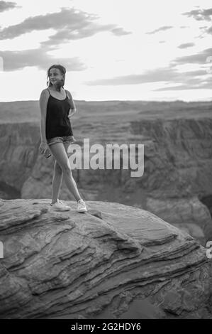 Jeune femme au coucher du soleil à Horseshoe Bend, Colorado River, Arizona, États-Unis. Banque D'Images