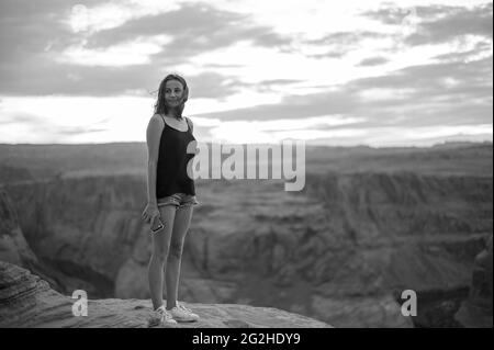 Jeune femme au coucher du soleil à Horseshoe Bend, Colorado River, Arizona, États-Unis. Banque D'Images