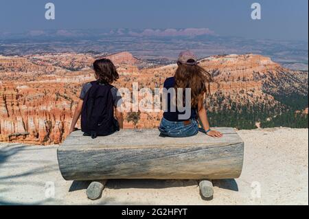 Garçon et fille ayant une place et regardant depuis inspiration point - un point d'observation avec vue sur le canyon au parc national de Bryce Canyon, Utah, États-Unis Banque D'Images