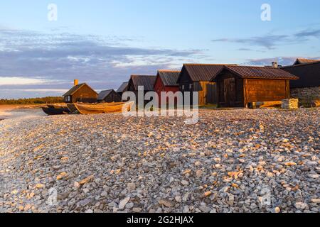 Maisons et bateaux dans la lumière du soir, village de pêcheurs historique Helgumannen, Suède, île de Farö Banque D'Images