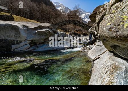 Dans une minuscule vallée latérale de la Valle Maggia, cet ancien pont en pierre s'étend sur un petit ruisseau de montagne. Banque D'Images