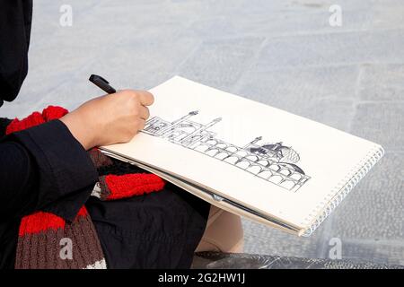 Un étudiant en architecture dessine la mosquée Sheikh Lotfollah sur la place Naghshe Jahan à Isfahan, en Iran Banque D'Images