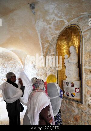 Pèlerins s'arrêtant par UNE statue représentant la Vierge Marie avec un bébé dans ses bras à l'entrée de l'Hospice autrichien dans la vieille ville de Jérusalem en Israël. Banque D'Images