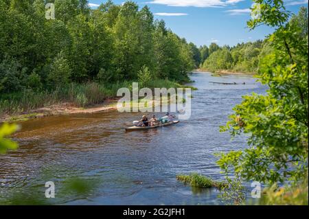 excursion en canoë sur la rivière forestière en été. trois hommes font du canoë sur la rivière forestière. La surface de l'eau reflète le ciel bleu. Touristes voyageant au Canada, h Banque D'Images