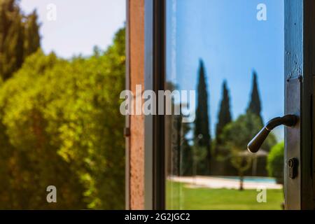 Parc paysage, miroir dans la porte vitrée d'une finca sur Majorque, vue détaillée de la poignée de porte Banque D'Images