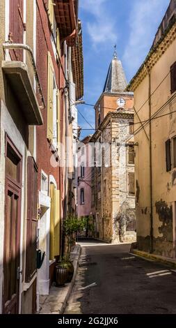 Allée du village à Saint Chinian avec vue sur le clocher de l'église notre Dame de l'Assomption au printemps. Banque D'Images