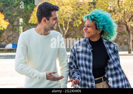 portrait d'un couple multiethnique discutant tranquillement à pied dans la ville Banque D'Images
