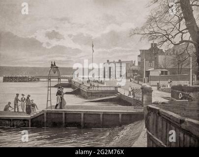 Vue de la fin du XIXe siècle sur les personnes arrivant en ferry à Cowes, une ville portuaire anglaise sur l'île de Wight. La ville est célèbre pour ses courses de yacht depuis la fondation de l'escadron de yacht royal en 1815. Il donne son nom à la plus ancienne régate régulière du monde, la semaine des Cowes, qui se déroule chaque année au cours de la première semaine d'août. Plus tard, les courses de bateau de moteur ont lieu. Banque D'Images