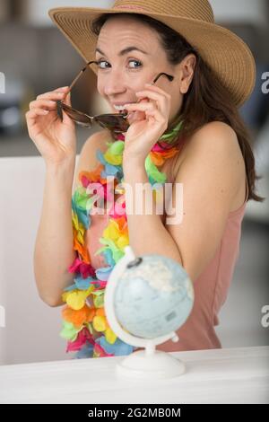 femme excitée par le monde entier mettant sur ses lunettes de soleil Banque D'Images