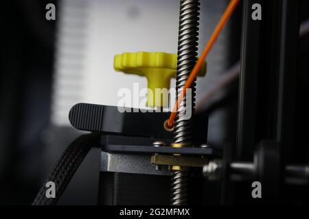 Moteur d'extrudeuse avec filament en pla de couleur orange pour la fabrication créative. Machine d'impression 3D moderne Banque D'Images