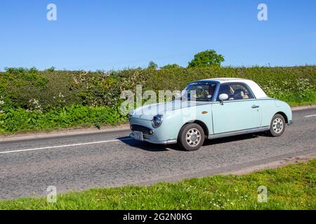 Années 1991 90 bleu blanc Nissan Figaro 1000cc essence cabriolet, en route pour Capesthorne Hall Classic May show, Cheshire, Royaume-Uni Banque D'Images