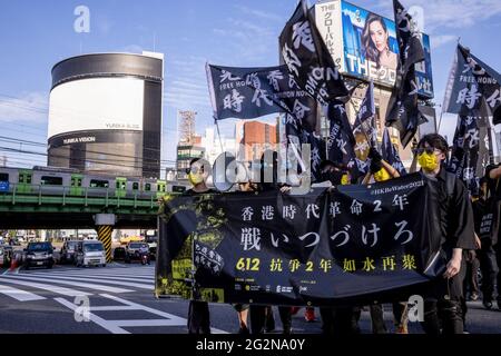 Tokyo, Japon. 12 juin 2021. Les manifestants tiennent une bannière et des drapeaux pendant la manifestation. Des manifestants pro-démocratie sont descendus dans la rue à Shinjuku au Japon pour marquer le deuxième anniversaire du mouvement de Hong Kong contre le projet de loi anti-extradition. Crédit : SOPA Images Limited/Alamy Live News Banque D'Images