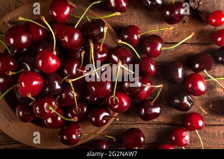 Cerises fraîches bio sur fond de bois. Banque D'Images