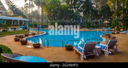 MUMBAI, INDE - 31 décembre 2021 : magnifiquement décoré et chaise autour de la piscine extérieure dans l'hôtel et le complexe avec un cocotier Banque D'Images