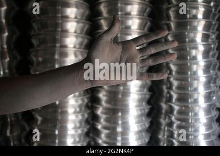 12 juin 2021, Dhaka, Dhaka, Bangladesh: MD Mahfuz enfant de 13 ans travail qui travaille dans une usine de fabrication de marmite en argent il montre ses mains étalés d'huile à la fin de son travail à Dhaka, Bangladesh le 12 juin, 2021.dans ce type d'usines d'aluminium environ 30-50% emploient sont le travail des enfants.ils obtiennent USD 3-3.5 par jour pour leurs travaux.la Journée mondiale contre le travail des enfants est célébrée le 12 juin chaque année. La Journée mondiale contre le travail des enfants est célébrée partout dans le monde afin de mettre fin au travail des enfants. Le travail des enfants est un grand problème dans le monde depuis longtemps. (Image de crédit : © Abu Sufian Banque D'Images