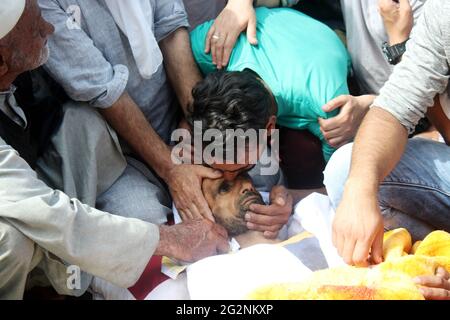 Srinagar, Inde. 12 juin 2021. Un parent de Basheer ahmad, un civil tué, embrasse son front lors d'un cortège funèbre au Cachemire de Sopore. Deux policiers et deux civils ont été tués samedi dans une attaque de millipitant dans le Sopore du nord du Cachemire, au moins trois autres, dont un policier, ont été blessés dans l'attaque (photo de Mohammad Abu Bakar/Pacific Press) Credit: Pacific Press Media production Corp./Alay Live News Banque D'Images