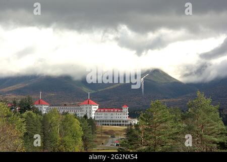 Toit rouge de l'un des plus grands hôtels des White Mountains du New Hampshire avec des nuages orageux menaçants qui enveloppent le Mont Washington. Banque D'Images