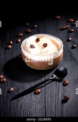 L'affogato à la vanille est recouvert de café chaud sur fond de bois noir Banque D'Images