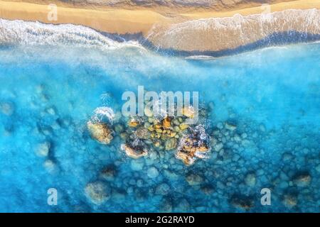 Vue aérienne sur la mer bleu clair avec vagues et plage de sable vide Banque D'Images