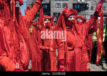 Falmouth, Cornwall, Royaume-Uni 12 juin 2021 rébellion d’extinction en marche pour protester contre les politiques « vertes » des entreprises et des gouvernements lors du sommet du G7. Les rebelles rouges mènent la marche à travers le centre-ville en se joignant aux médecins de XR et aux épurateurs sales, finissant au centre des médias. Banque D'Images