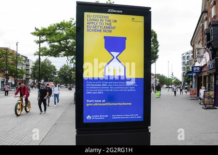 Hounslow, Royaume-Uni. 11 juin 2022. Une publicité pour le système de règlement de l'UE apparaît sur un écran dans la rue haute. Le gouvernement britannique utilise de telles annonces pour inciter les citoyens de l'UE vivant au Royaume-Uni d'ici le 31 décembre 2020 à appliquer le système de règlement de l'UE d'ici le 30 juin 2021. Crédit : Mark Kerrison/Alamy Live News Banque D'Images