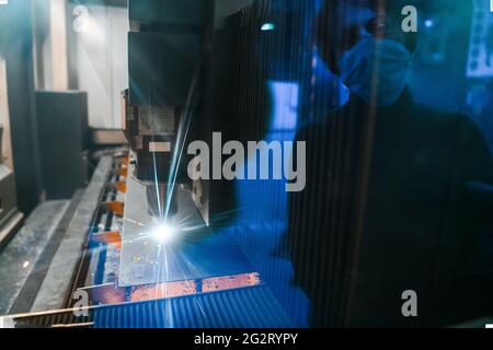 Étincelles voler hors machine head pour le traitement du métal sur métal laser usine métallurgique arrière-plan. La fabrication de pièces pour la production automobile Banque D'Images