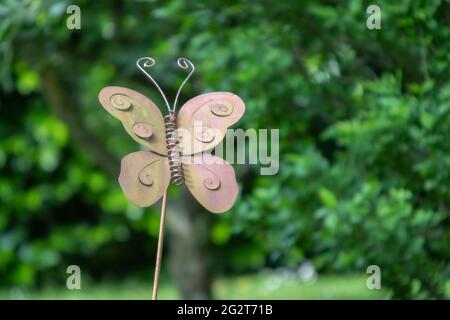 papillon en métal rouillé sur un bâton dans un jardin Banque D'Images