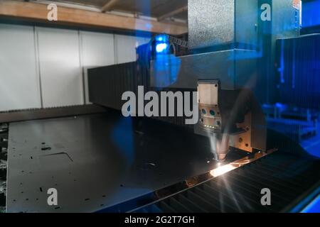 Étincelles voler hors machine head pour le traitement du métal sur métal laser usine métallurgique arrière-plan. La fabrication de pièces pour la production automobile Banque D'Images