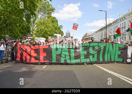 Londres, Royaume-Uni. 12 juin 2021. Les manifestants défilent avec une bannière « Palestine libre » à travers Knightsbridge en direction de l'ambassade d'Israël. Des milliers de personnes ont défilé pour exiger la justice pour la Palestine et ont appelé le G7 à mettre fin à la coopération militaire avec Israël et à imposer des sanctions. (Crédit : Vuk Valcic / Alamy Live News). Banque D'Images