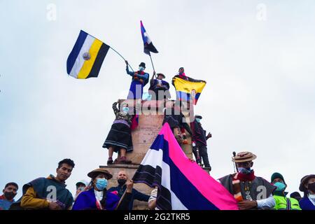 Les peuples indigènes Misak prennent la place de 'Monumento a los Reyes Catolicos'. Dans cette place spécifique se trouvaient les sculptres de Chrisropher Columbus et Isabel la Catolica, quelques jours avant qu'ils ne tentent de retirer ces sculptures et de riposter par la police nationale colombienne. Les sculptres ont été ramenés par le ministère de la culture la nuit qui a suivi les affrontements. À Bogota, Colombie, le 11 juin 2021. Banque D'Images