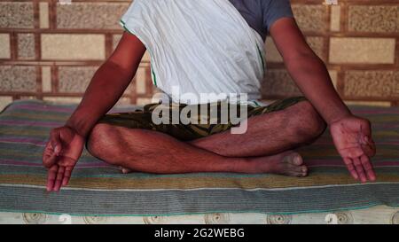 Homme indien à la recherche de l'illumination par la méditation, détendu jeune homme exécutant la routine de yoga. Concept de journée de yoga. Banque D'Images