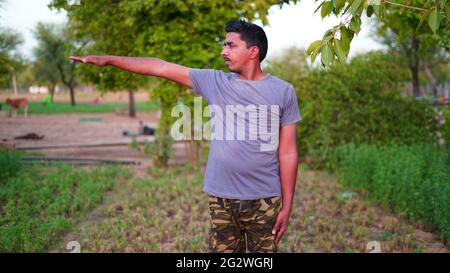 Homme en bonne santé faisant de l'exercice d'étirement sur l'herbe verte au parc. Concept de journée de yoga Banque D'Images