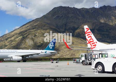Queenstown, Nouvelle-Zélande - mars 6 2015 ; les montagnes forment la toile de fond des avions garés à l'aéroport. Banque D'Images