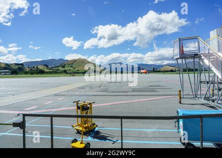 Queenstown, Nouvelle-Zélande - Mars 6 2015 ; les montagnes forment le décor de l'avion de couleur orange arrivant à l'aéroport . Banque D'Images