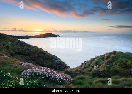Towan Head près de Newquay, sur la côte nord de Cornwall. L'image a été prise au coucher du soleil au printemps en utilisant une longue exposition pour rendre l'eau floue. Banque D'Images