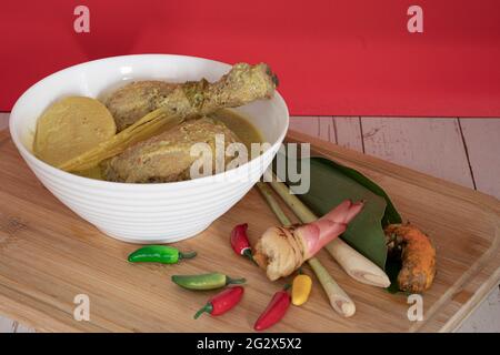 Poulet en Masak Lemak Cili API dans un bol blanc. C'est un plat local populaire en Malaisie. Points de mise au point sélective. Arrière-plan flou Banque D'Images