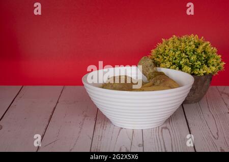 Poulet en Masak Lemak Cili API dans un bol blanc. C'est un plat local populaire en Malaisie. Points de mise au point sélective. Arrière-plan flou Banque D'Images