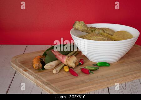 Poulet en Masak Lemak Cili API dans un bol blanc. C'est un plat local populaire en Malaisie. Points de mise au point sélective. Arrière-plan flou Banque D'Images