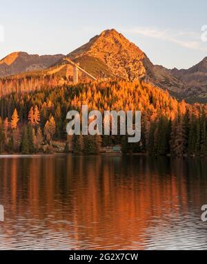 Lac Strbske pleso avec les sommets de Predne Solisko, Mlynicke Solisko et Strbske Solisko dans les montagnes Vysoke Tatry en Slovaquie pendant la mornine d'automne Banque D'Images