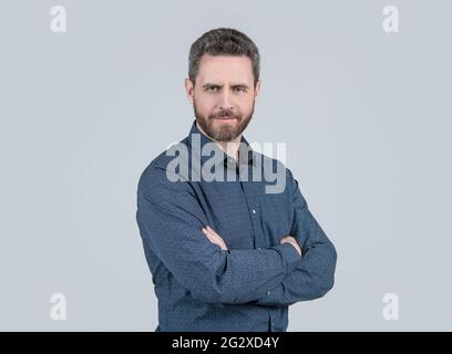 Homme barbu dans une chemise de style décontracté garder les bras croisés sentiment de confiance fond gris, confortable Banque D'Images