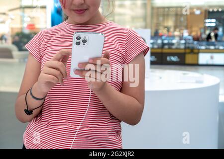 Une charmante petite fille tient dans ses bras Apple iPhone 12 Pro Max argent dans l'Apple Store. La face n'est pas visible. Russie, Tatarstan, juin 10, Banque D'Images