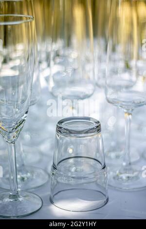 Gros plan de différents verres, verres à champagne et verre à cocktail sur une table avec nappe blanche, accent sur le verre à cocktail Banque D'Images