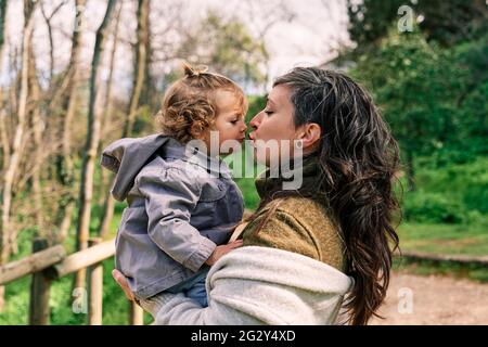 jeune mère tenant sa fille dans ses bras et s'embrassant Banque D'Images