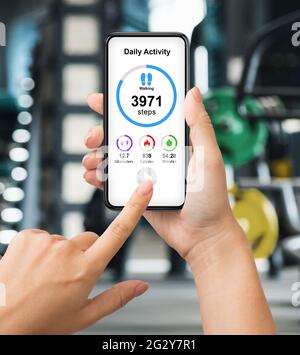 Pantacourt d'une femme qui vérifie son activité quotidienne tout en faisant de l'exercice à la salle de gym Banque D'Images