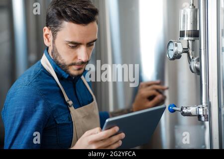 Portrait de l'ouvrier de brasserie vérifiant le processus de fermentation, la technologie et l'application pour les petites entreprises Banque D'Images