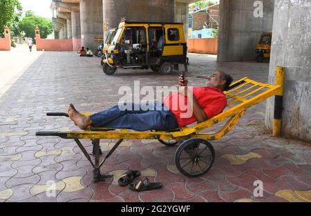 Beawar, Rajasthan, Inde, juin 13,2021: Un coolie (porteur) reste comme il attend de rares clients à l'extérieur de la gare ferroviaire pendant le week-end de confinement en raison de la pandémie de COVID-19 à Beawar. Crédit : Sumit Saraswat/Alay Live News Banque D'Images